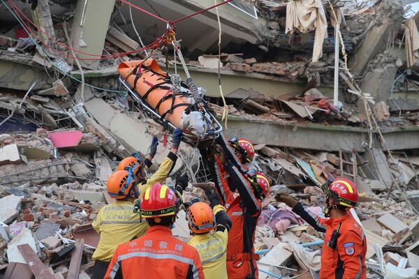 In this photo released by Xinhua News Agency, members of a China search and rescue team transfer a pregnant survivor from a collapsed building in the aftermath of an earthquake in Mandalay, Myanmar, Monday, March 31, 2025. (Myo Kyaw Soe/Xinhua via AP)