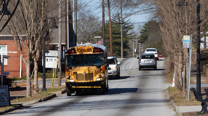 A school bus drives down Main Street in Stone Mountain Tuesday, January 18, 2022.   STEVE SCHAEFER FOR THE ATLANTA JOURNAL-CONSTITUTION