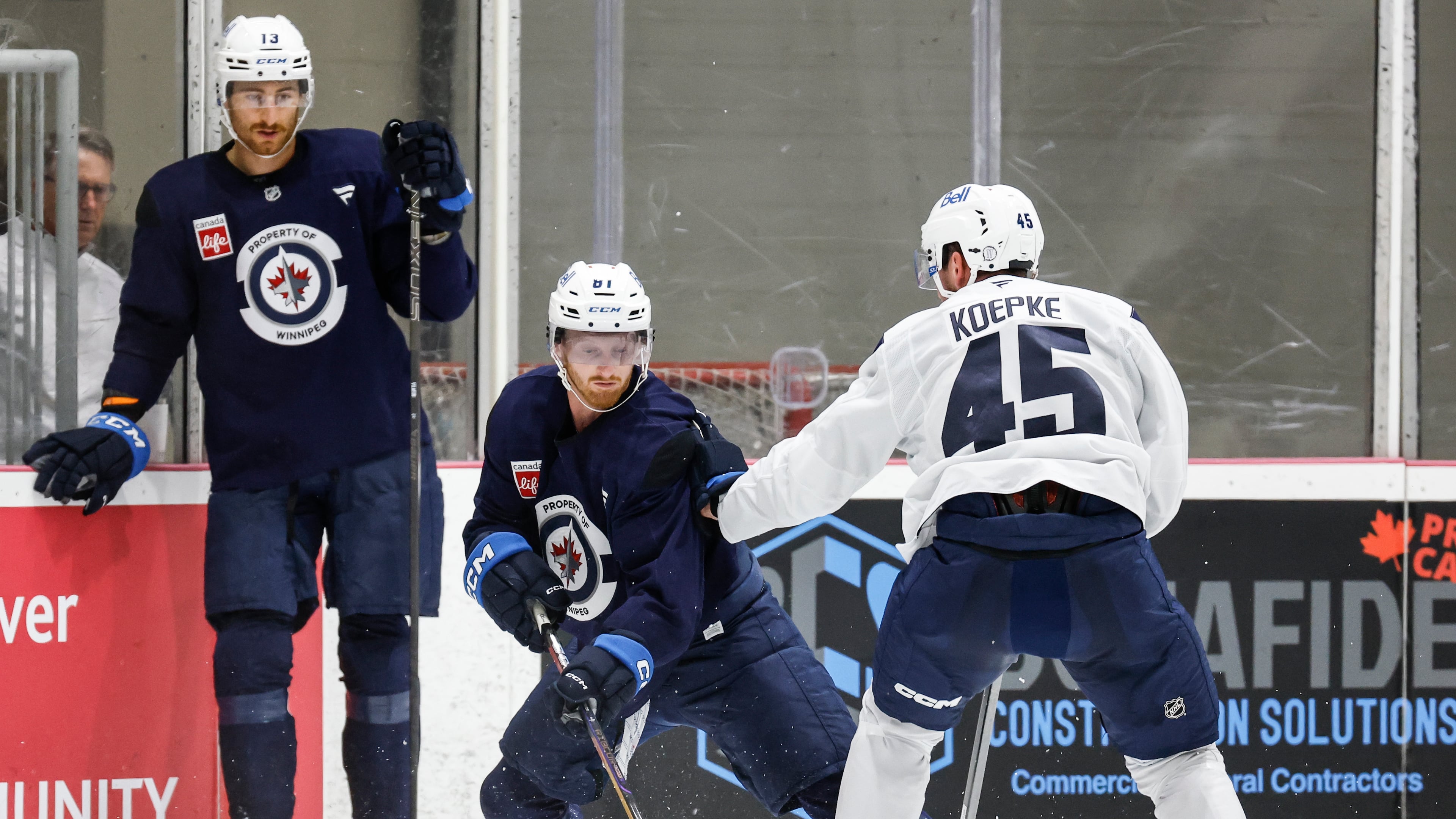 Winnipeg Jets' Gabriel Vilardi (13) looks on as Kyle Connor (81) and Cole Koepke (45) battle in the corner during NHL hockey training camp in Winnipeg, Manitoba, Thursday, Sept. 18, 2025. (John Woods/The Canadian Press via AP)