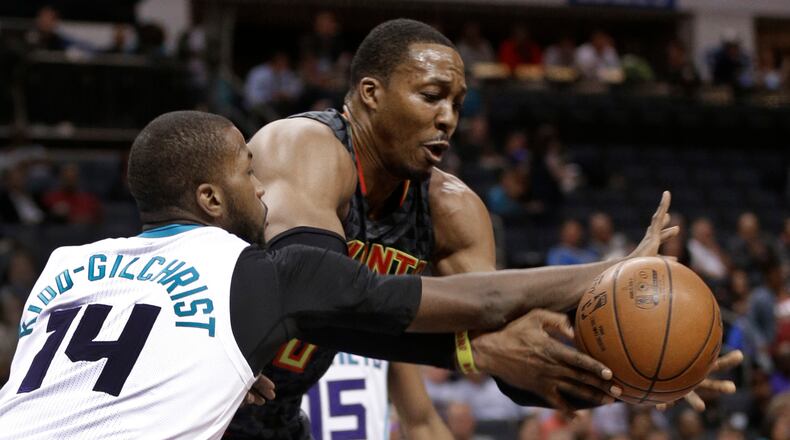 Atlanta Hawks’ Dwight Howard, right, and Michael Kidd-Gilchrist, left, chase a loose ball during the first half of an NBA basketball game in Charlotte, N.C., Monday, March 20, 2017. (AP Photo/Chuck Burton)