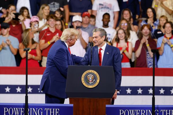 President Donald Trump (left) welcomes Republican nominee for governor Rick Jackson on stage during his event at Wheeler High School in Marietta on Wednesday. (Arvin Temkar/AJC)