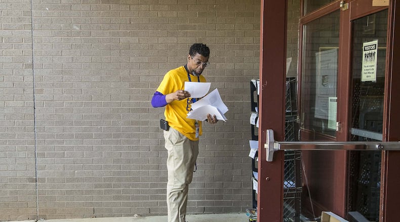 Shadow Rock Elementary School principal Ethan Suber collects packets of school work for drop-offs at the school in Lithonia, Monday, April 27, 2020. Each week Suber works with assistant principal Jason Moffitt to print out classwork for more than 100 students who do not have access to a computer or the internet. The classwork is filed in bins and left outside for parents and guardians to pick-up. A bin for completed work is also available to help teachers keep up with all of their students’ work. ALYSSA POINTER / ALYSSA.POINTER@AJC.COM