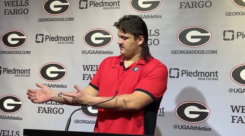 Georgia offensive lineman Tate Ratledge points to a "DW" tattoo on the inside of his right wrist. Those are the initials of his former teammate, Devin Willock, who died in a car crash Jan. 15. (Chip Towers/ctowers@ajc.com)