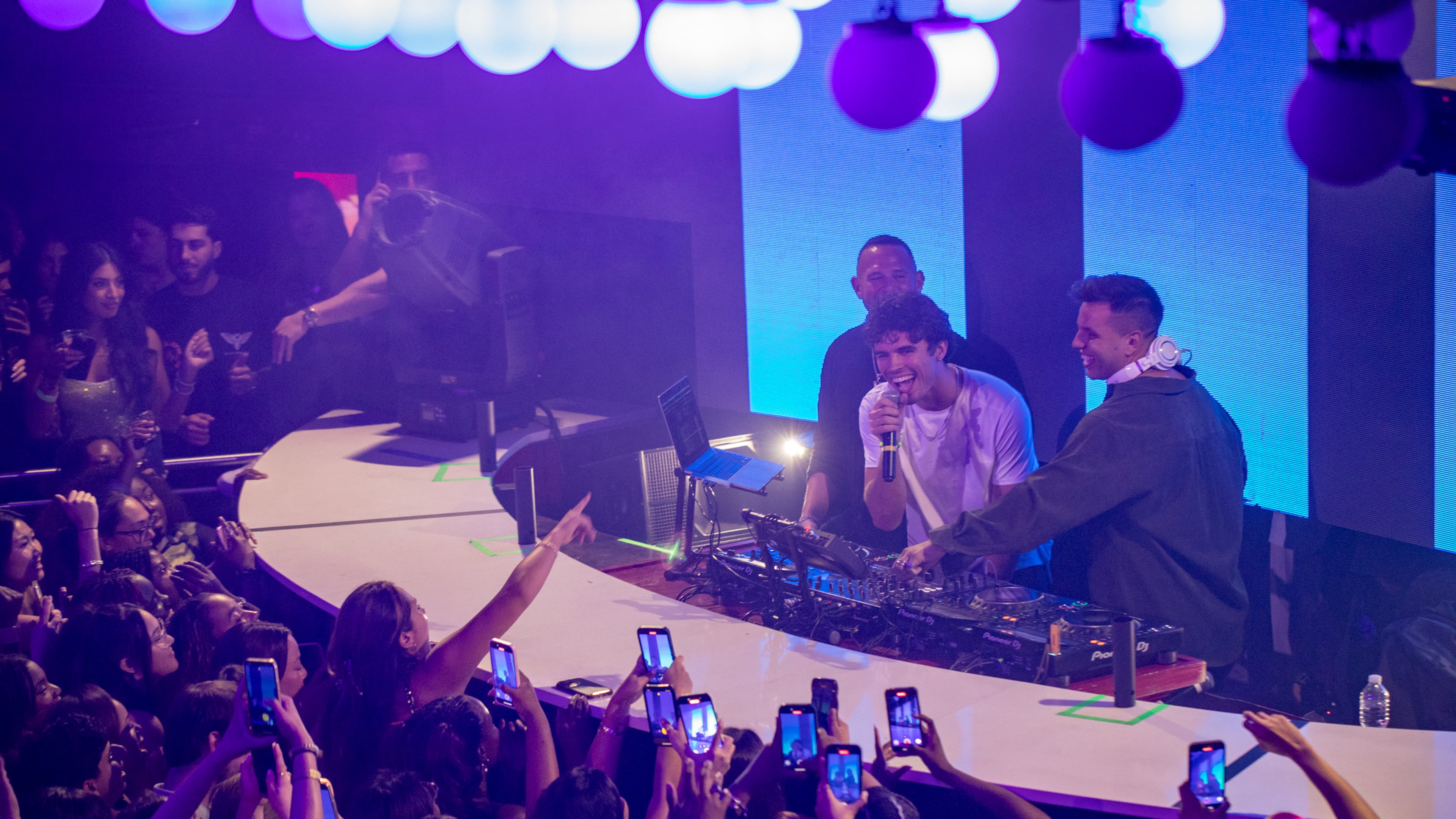 Nic Vansteenbergh (center) makes an appearance at District Atlanta on Thursday, Sept 11, 2025, where he joins DJ Bogi (right) on stage. (Jenni Girtman for the AJC)