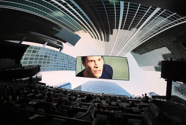 A scene from the film "The Matrix" is surrounded by immersive urban visuals during a screening of "The Matrix in Shared Reality" on Wednesday, May 28, 2025, at Cosm Los Angeles in Inglewood, Calif. (AP Photo/Chris Pizzello)
