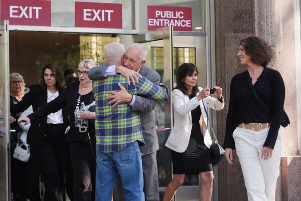 Attorney Mark Geragos, center, representing Erik and Lyle Menendez, gets a hug as leaves the courthouse after the brothers' resentencing hearing Tuesday, May 13, 2025, in Los Angeles. (AP Photo/Damian Dovarganes)