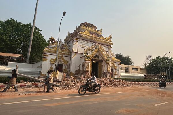 Vehicles make their way past Maharmyatmuni pagoda in the aftermath of an earthquake, in Mandalay, central Myanmar, Sunday, March 30, 2025. (AP Photo/Thein Zaw)
