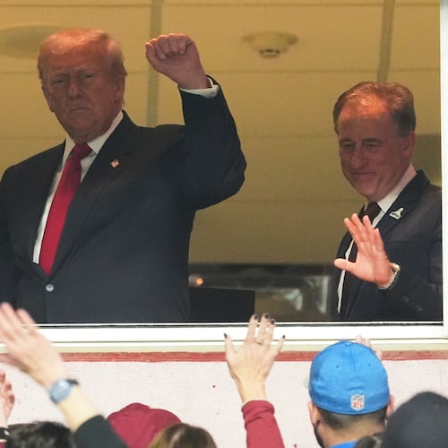 President Donald Trump, center, gestures to the crowd alongside Defense Secretary Pete Hegseth, left, and Washington Commanders owner Josh Harris, as they attend an NFL football game between the Commanders and the Detroit Lions at Northwest Stadium in Landover, Md., Sunday, Nov. 9, 2025. (AP Photo/Jacquelyn Martin)