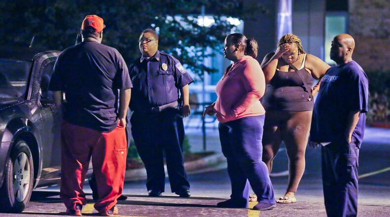 Family members of Mary Oliver and a security guard gathered at the gate of Baptist Towers on Myrtle Drive Monday, June 18, 2013. A resident of a southwest Atlanta senior citizen high rise allegedly stabbed two of his neighbors late Monday, June 18, 2013 killing one just hours before she would have celebrated her 76th birthday, police said.