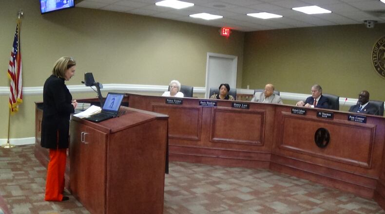 Diane Prevatt, owner of Hand Me Ups, was among business owners who appealed to Powder Springs City Council members on Jan. 16 to change the new downtown parking plan that would reduce parking behind her business and others. Seated, left to right, are Councilwomen Nancy Farmer and Doris Dawkins, Councilman Henry Lust, City Attorney Richard Calhoun and Mayor Al Thurman. Carolyn Cunningham for the AJC
