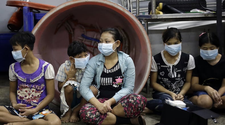 In this Nov. 9, 2015, photo, Eae Hpaw (center), 16, an undocumented child worker, sits with children and teenagers to be registered by officials during a raid on a shrimp shed in Samut Sakhon, Thailand. Ten children were taken to a government shelter for human trafficking. AP PHOTO / DITA ALANGKARA