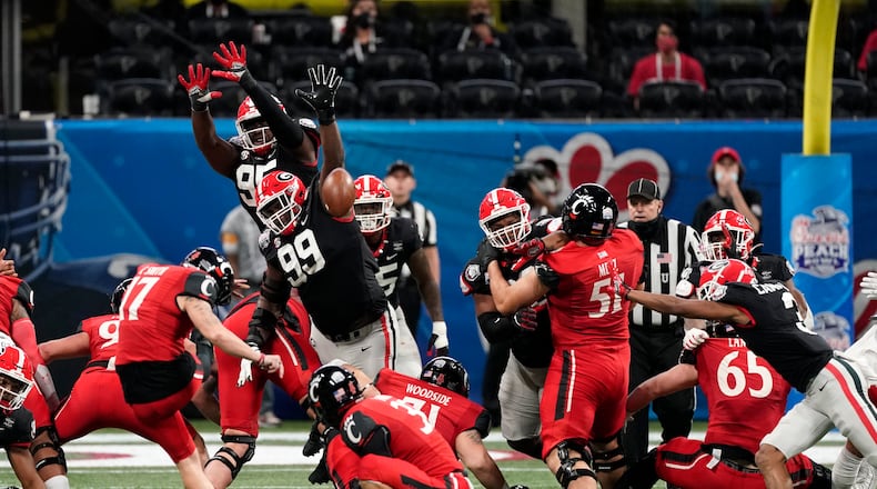 Georgia's Jordan Davis (99) throws a hand up just moments before blocking a Cincinnati field-goal try on the way to the Bulldogs' 24-21 win over the Bearcats in the 2020 Chick-fil-A Peach Bowl on Jan. 1, 2021, in Atlanta. (Paul Abell/UGA Athletics)