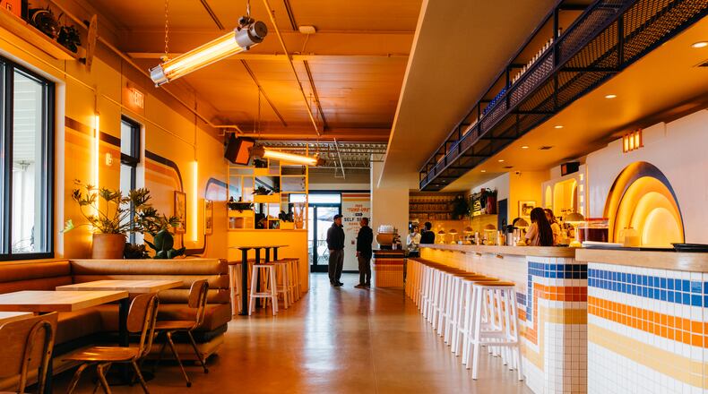 A long shot of the dining room at Muchacho with tables on the left and a bar/counter on the right.