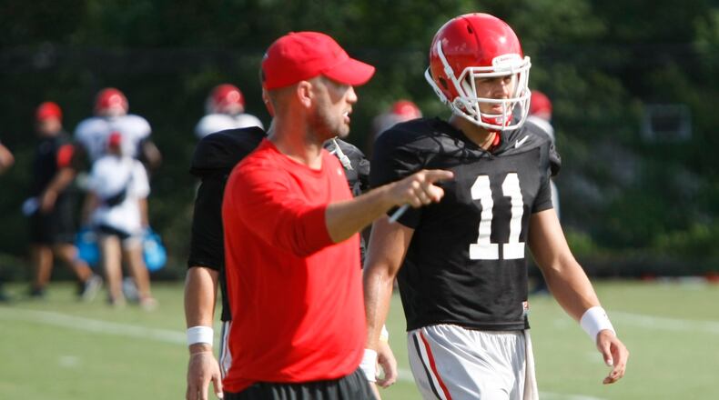 UGA offensive coordinator Brian Schottenheimer walks with quarterback Greyson Lambert (11) .