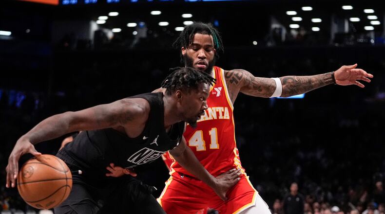 Brooklyn Nets' Dorian Finney-Smith, left, drives past Atlanta Hawks' Saddiq Bey (41) during the second half of an NBA basketball game Thursday, Feb. 29, 2024, in New York. (AP Photo/Frank Franklin II)