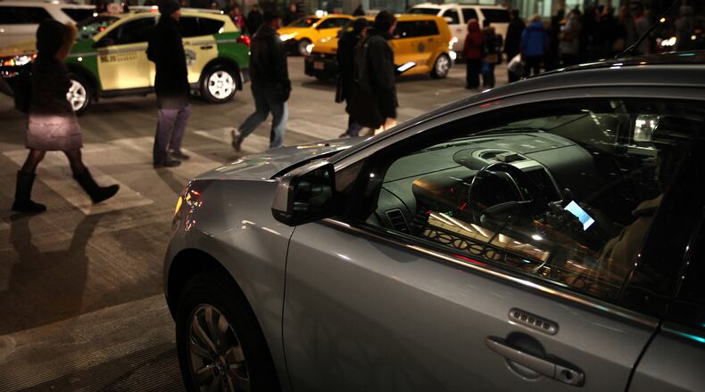 A driver texts as she waits for the left green arrow on Nov. 12, 2013, in Chicago. (Adam Wolffbrandt/Chicago Tribune/TNS)