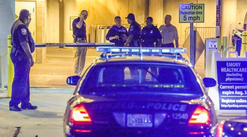 Police investigate after carjacking suspects abandoned a stolen vehicle at an Emory Univeristy parking deck. JOHN SPINK/JSPINK@AJC.COM
