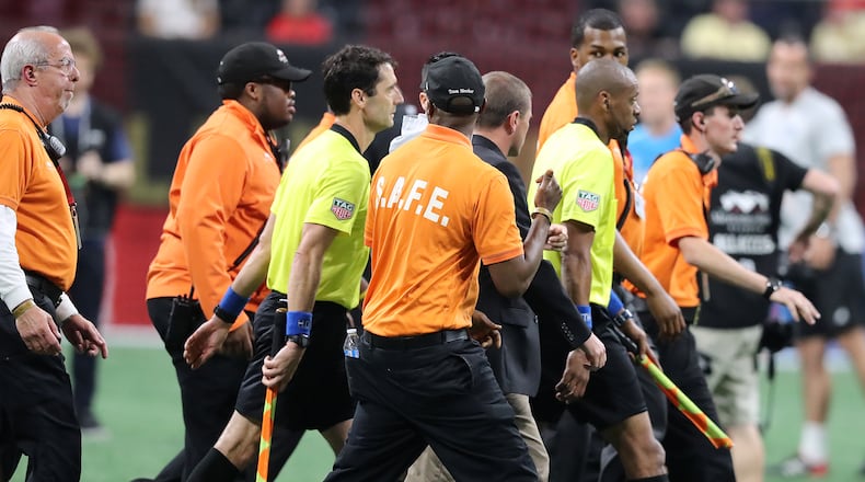 Security guards escort the game officials off the field after a heated match between Atlanta United and Sporting Kansas City in a MLS soccer match on Wednesday, May 9, 2018, in Atlanta. Curtis Compton/ccompton@ajc.com