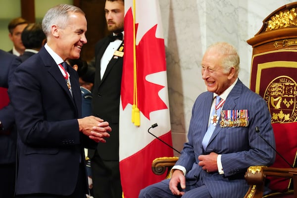 Canadian Prime Minister Mark Carney, left, speaks with King Charles ahead of the King delivering the speech from the throne in the Senate in Ottawa on Tuesday, May 27, 2025. (Chris Young/The Canadian Press via AP)