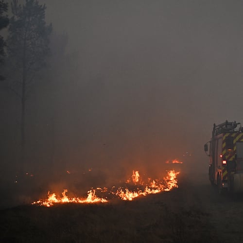 A fire engine drives through smoke of a wildfire raging near Marcheprime, outside, Bordeaux, France, Sunday, July 26, 2026. (AP Photo/Emma Da Silva)