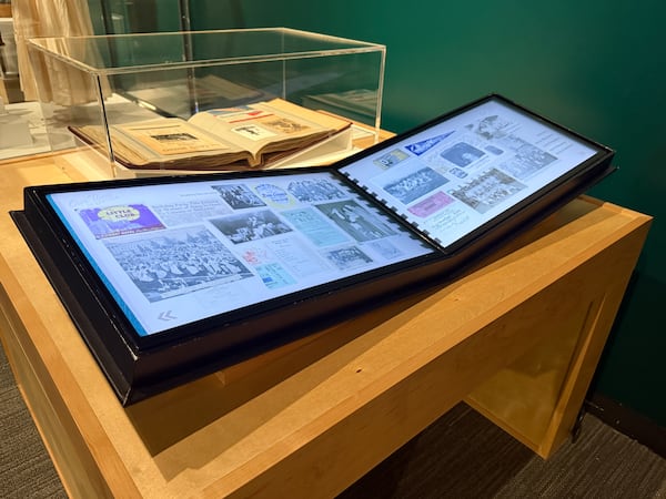 A digital scrapbook was created using real photos, letters and memorabilia donated to the National WWII Museum. Behind the digital version is an actual scrapbook used by a woman who served in WWII. (Danielle Charbonneau/AJC)