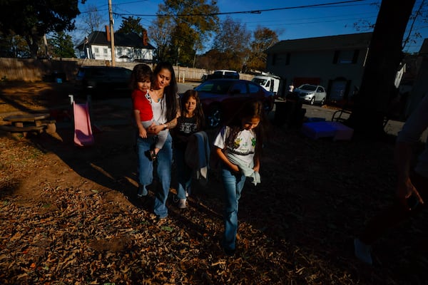 Ceudy Gutierrez walks with her kids, Maria Jose, Maria Camila, and Matias (2), after getting the twin sisters off the school bus on Tuesday, Nov. 18, 2025. (Miguel Martinez/ AJC)