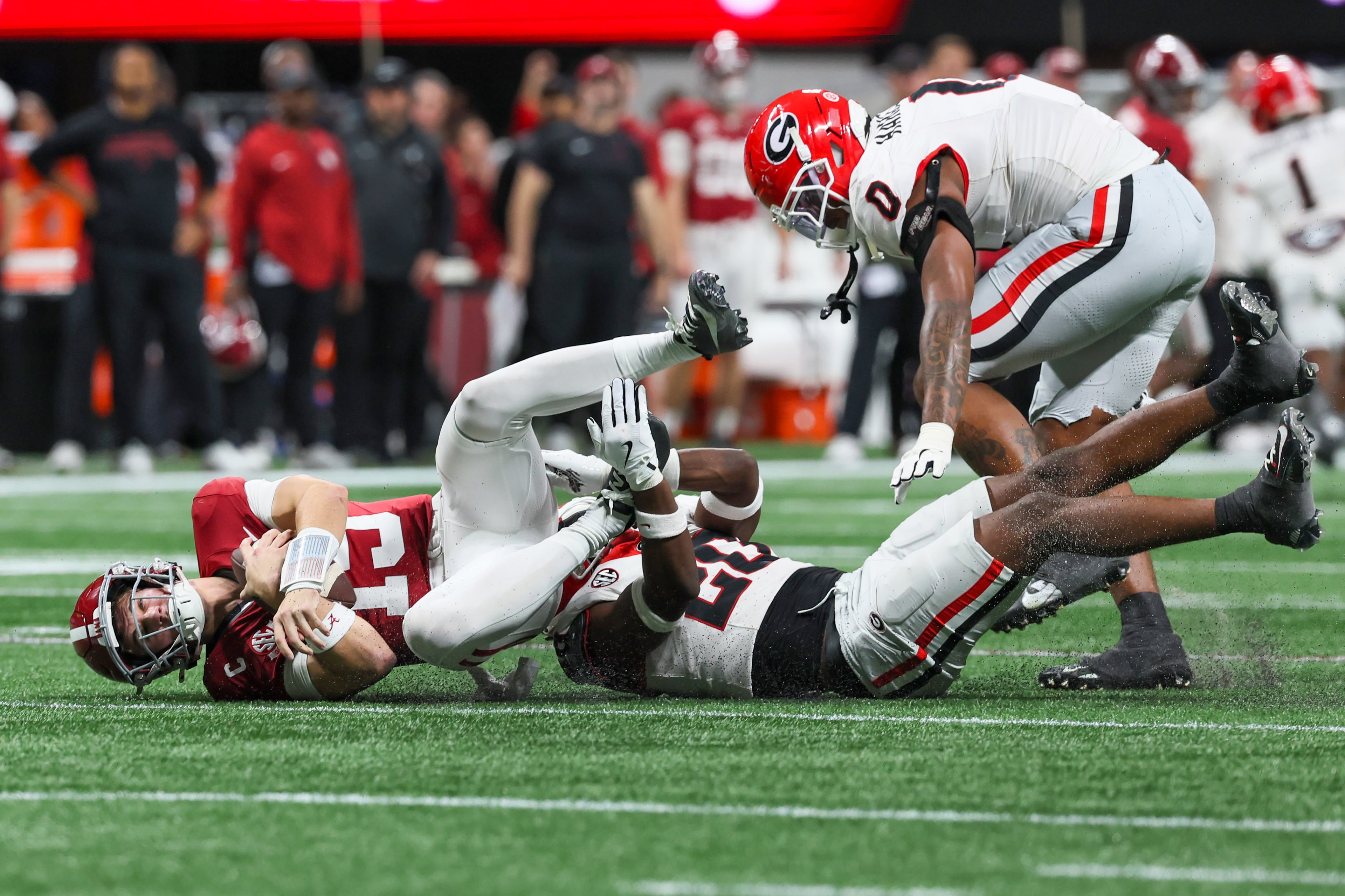 Alabama quarterback Ty Simpson (15) is sacked by Georgia defensive back Jacorey Thomas (20) during the third quarter of the SEC Championship game at Mercedes-Benz Stadium, Saturday, Dec. 6, 2025, in Atlanta. (Jason Getz / AJC)