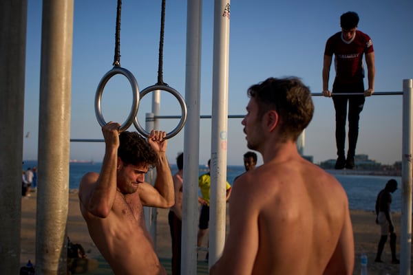 People work out in an open-air gym next to the beach in Barcelona, Spain, Tuesday, June 25, 2025. (AP Photo/Emilio Morenatti)