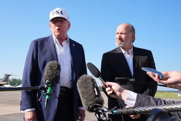 President Donald Trump, left, speaks with reporters as Commerce Secretary Howard Lutnick listens before boarding Air Force One at Morristown Municipal Airport in Morristown, N.J., Sunday, July 6, 2025, en route to Washington. (AP Photo/Jacquelyn Martin)