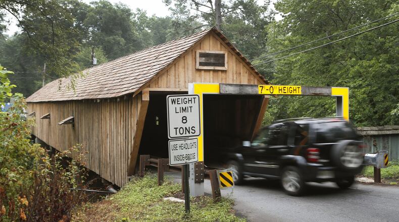 Traffic makes its way through the bridge. The Concord Covered Bridge over Nickajack Creek, a historic covered bridge that was entered into the the National Register of Historic Places in 1980, was renovated last fall for four months and at a cost of $802,000 SPLOST, funds. The bridge has a low clearance and gets hit multiple times per year, usually by rented trucks that don’t clear the warning beam. The fee to fix the warning beams, which look like big yellow staples that indicate the seven-foot heights limit, is between $400 and $600 and billed to the driver. BOB ANDRES /BANDRES@AJC.COM