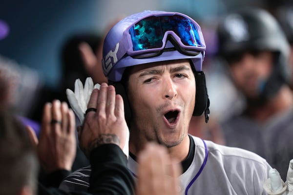 Colorado Rockies' Michael Toglia is congratulated by teammates in the dugout after hitting a grand slam during the Xhird inning of a baseball game against the Los Angeles Dodgers, Wednesday, April 16, 2025, in Los Angeles. (AP Photo/Mark J. Terrill)