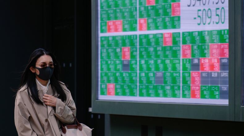 A person walks in front of an electronic stock board showing Japan's Nikkei index at a securities firm Thursday, April 30, 2026, in Tokyo. (AP Photo/Eugene Hoshiko)