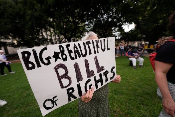 FILE - A protestor holds a sign during a demonstration in New Orleans, July 1, 2025. (AP Photo/Gerald Herbert, File)