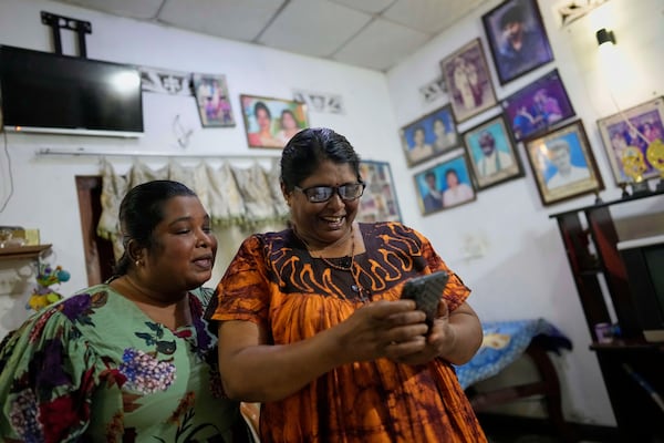 Thavaraththinam Tharsini, left, joins her mother Thavarathnam Pushparani who is on a video call with her granddaughter at their home in Paranthan, Sri Lanka, Wednesday, April 2, 2025. (AP Photo/Eranga Jayawardena)
