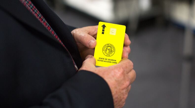 Merle King, executive director for the Center for Election Systems at Kennesaw State University, holds a voter access card, Thursday, Oct. 20, 2016, in Kennesaw, Ga.