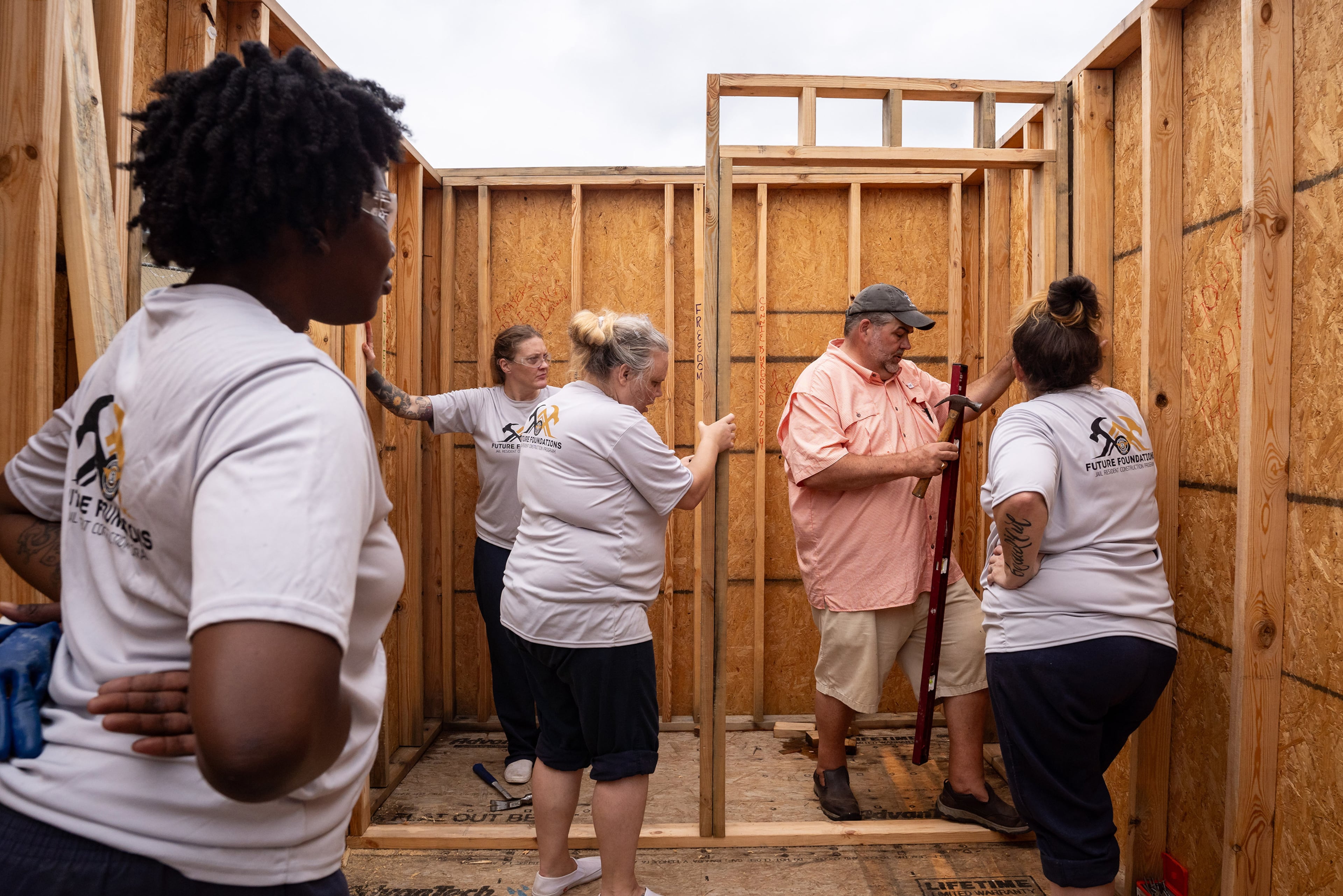 Inmates at the Athens-Clarke County Jail work with Jonathan Sims, a volunteer construction skills instructor, to build a tiny home in the jail yard in Athens. (Seeger Gray/AJC 2024)