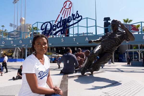 FILE - Ayo Robinson, the granddaughter of baseball great Jackie Robinson, pauses next to a sculpture of her grandfather on Jackie Robinson Day before a baseball game between the Los Angeles Dodgers and the Washington Nationals at Dodger Stadium in Los Angeles, Monday, April 15, 2024. (AP Photo/Damian Dovarganes, File)