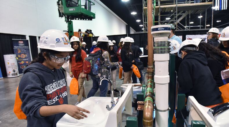 March 21, 2019 Atlanta - Xiomara Calleas (left), 11, student from Ridgeview Charter School in Sandy Springs, tries during 2019 CEFGA CareerExpo at Georgia International Convention Center on Thursday, March 21, 2019. Getting students career ready has taken on momentum in recent years — so much so that schools are starting as early as elementary school exposing kids to fields such as construction trades. The Construction Education Foundation of Georgia Career Expo draws schools across the state to learn about options. HYOSUB SHIN / HSHIN@AJC.COM