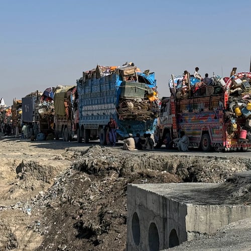 Afghan refugees sit beside trucks loaded with their belongings as they wait their turn to leave for their homeland through a border crossing point which partially opens following Oct.19 ceasefire, on the outskirts of Chaman, a border town on the Pakistan Afghan border, Wednesday, Oct. 29, 2025. (AP Photo/H. Achakzai)