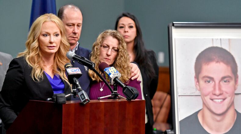 In this May 5, 2017, file photo, Centre County, Pa., District Attorney Stacy Parks Miller, left, announces findings an investigation into the death of Penn State University fraternity pledge Tim Piazza, seen in photo at right, as his parents, Jim and Evelyn Piazza, second and third from left, stand nearby during a news conference in Bellefonte, Pa.