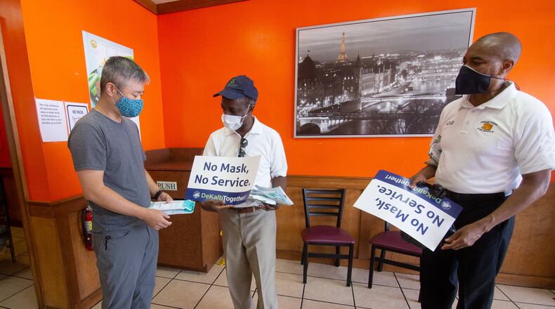 CEO Michael Thurmond talks with the owner of J Buffalo Wings David Sung as he hands out masks and No Mask, No Service signs to businesses on Wesley Chapel Rd in Decatur, Saturday 25, 2020. STEVE SCHAEFER FOR THE ATLANTA JOURNAL-CONSTITUTION