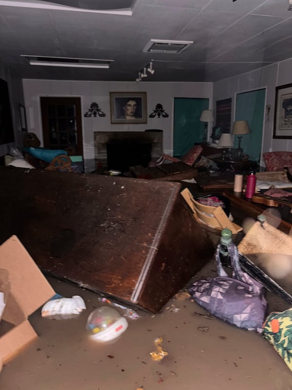 Furniture and personal belongings float in floodwaters inside Alden Towler's cabin in Hunt, Texas, at 4:20 a.m. on Friday, July 4, 2025. (Shabd Simon-Alexander via AP)