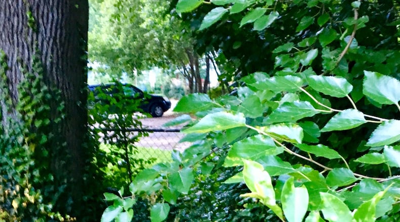 Exeter Road in Avondale Estates (where the car’s parked) is where a short cut through (seen in the background) runs from Exeter through the foliage and to a gate (not pictured) next to Forrest Boulevard/Craigie Avenue. East Decatur Greenway wants to clean up the overgrowth, clear the cut through and open the gate so cyclists and pedestrians can turn right on Craigie, which leads directly to the new EDG/PATH trail a half mile away. Bill Banks for the AJC