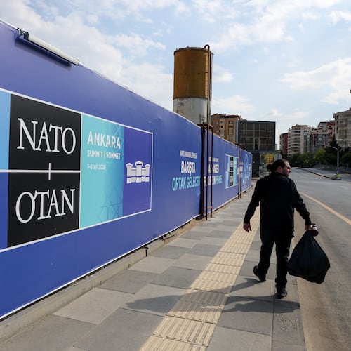 A man walks past a banner ahead of the NATO Summit in Ankara, Turkey, Sunday, July 5, 2026. (AP Photo/Riza Ozel)