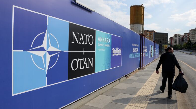 A man walks past a banner ahead of the NATO Summit in Ankara, Turkey, Sunday, July 5, 2026. (AP Photo/Riza Ozel)
