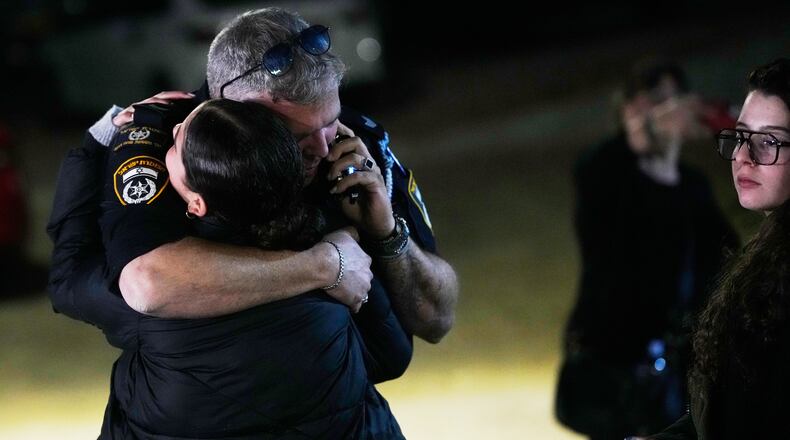 A police officer hugs a family member of Israeli hostage Ran Gvili after the announcement that his remains were the last to be recovered from Gaza, at his home in the village of Meitar, southern Israel, Monday, Jan. 26, 2026. (AP Photo/Ohad Zwigenberg)