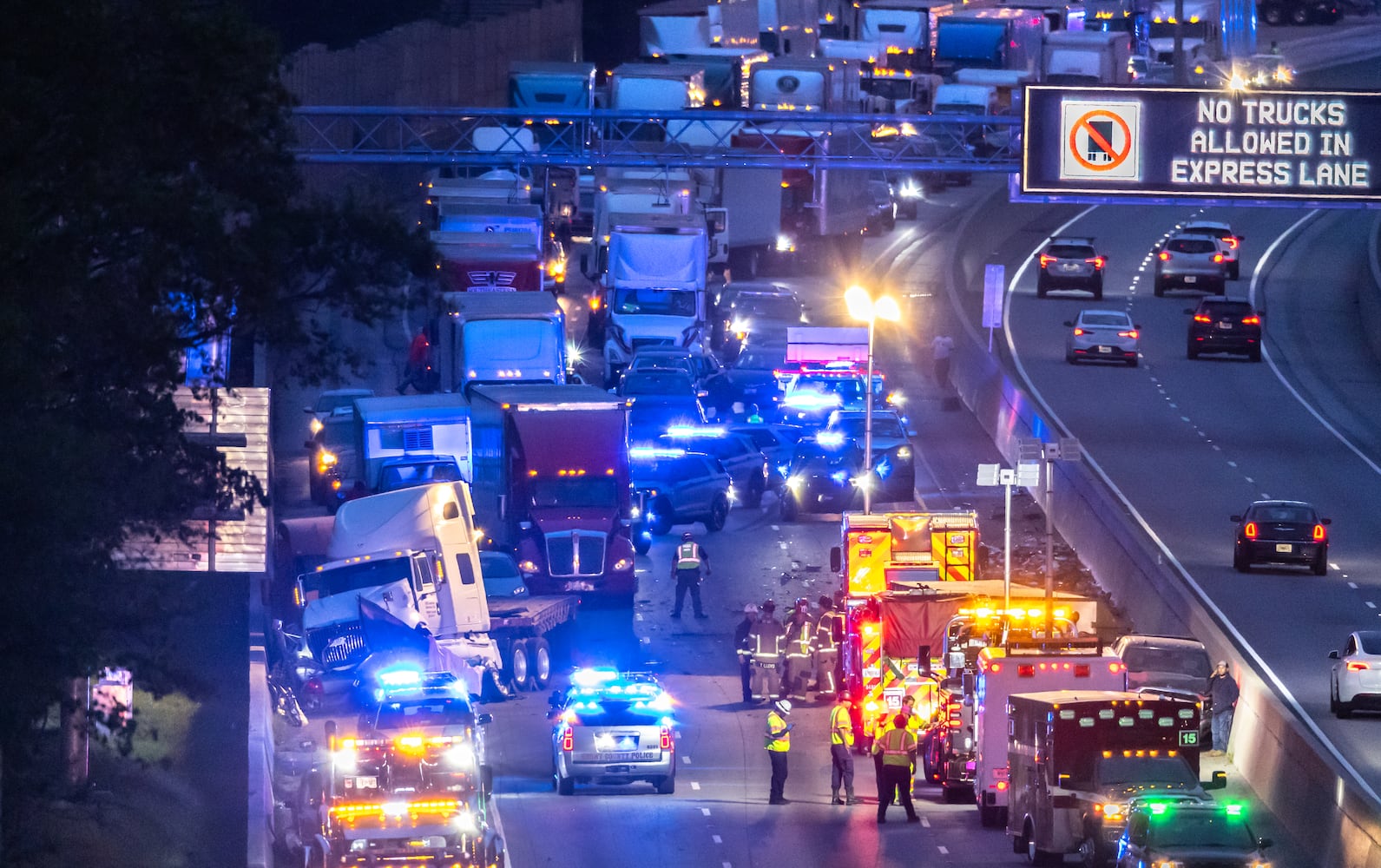 All lanes reopened on I-75 South in Henry County after a six hour investigation of a deadly crash involving multiple tractor-trailers that brought travel to a standstill Tuesday morning, April 16, 2024. The collision happened near mile marker 221, or just past Jodeco Road and before Jonesboro Road, at around 4:40 a.m., according to the Georgia Department of Transportation. The lanes were cleared by 11:20 a.m., GDOT stated, though traffic remained backed up for miles. Henry police confirmed at least one fatality. They did not release additional information about the extent of any other injuries. After the crash, a crane was used to lift a vehicle that appeared to have been pinned under one of the tractor-trailers. Several other big rigs remained on the shoulder of the interstate during the cleanup efforts. Police did not share details about what led to the wreck, as investigators processed the scene. Motorists were told to avoid the area. Backups extended for several miles, reaching I-675 as of 11:30 a.m. Commuters used U.S. 19/41, Ga. 42 and Ga. 155 as alternates, though traffic on those roads moved slowly, according to the WSB 24-hour Traffic Center. (Photo by John Spink/AJC)