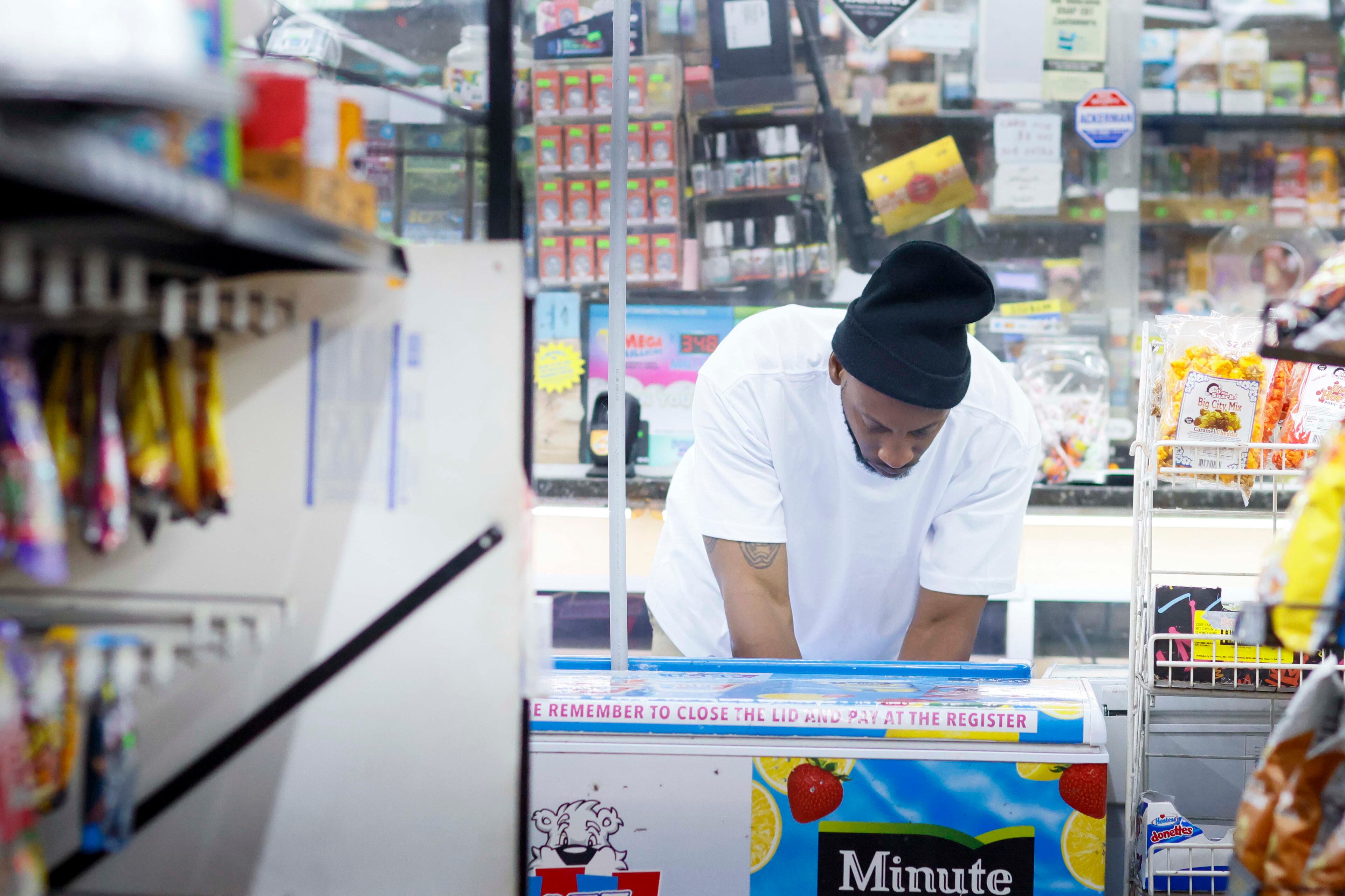 Connell Daniels Jr. organizes merchandise after midnight. (Miguel Martinez/AJC)