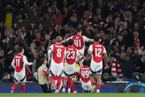 Arsenal's Declan Rice, top, celebrates after scoring his side's second goal during the Champions League quarterfinal first leg soccer match between Arsenal and Real Madrid at the Emirates Stadium in London, Tuesday, April 8, 2025. (AP Photo/Frank Augstein)