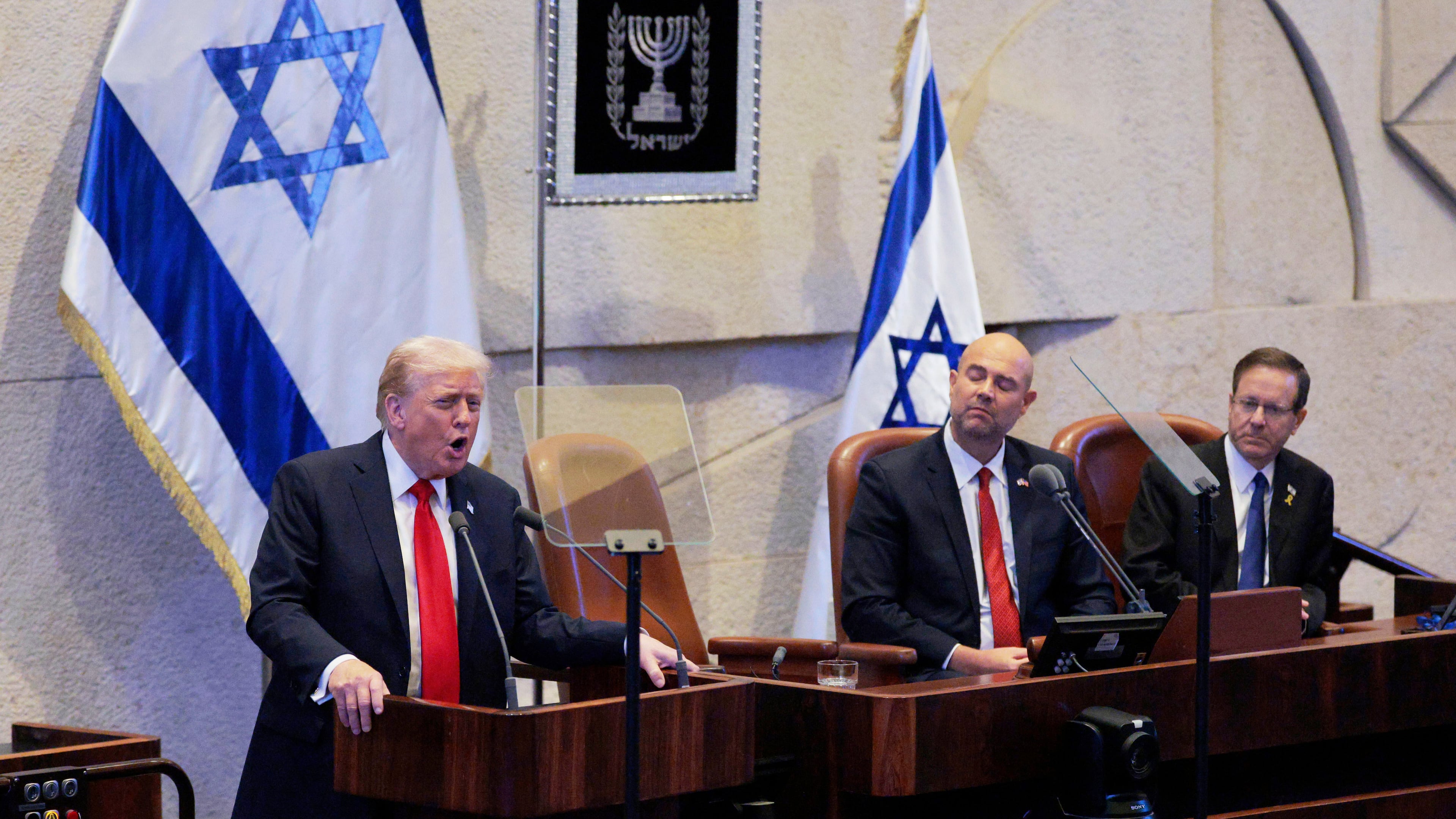 President Donald Trump addresses the Knesset, Israel's parliament, next to Amir Ohana, Speaker of the Israeli Knesset, and Israeli President Isaac Herzog, Monday, Oct. 13, 2025, in Jerusalem. (Chip Somodevilla/Pool via AP)